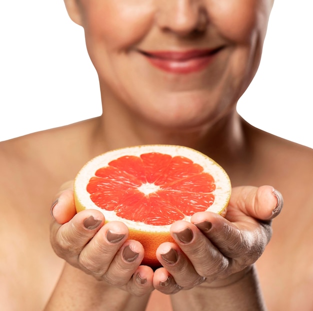 Free PSD senior woman with grapefruit for skincare