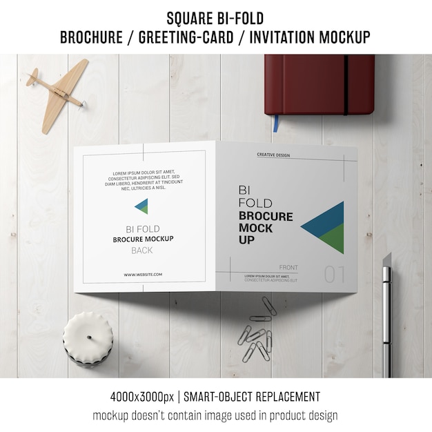 Square bi-fold brochure or greeting card mockup with decoration on tabletop