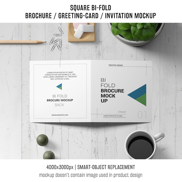 無料PSD 正方形の2つ折りのパンフレットまたは木製のワークスペース上のグリーティングカードのモックアップ