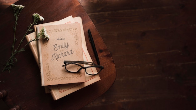 Top view of books with glasses and pen