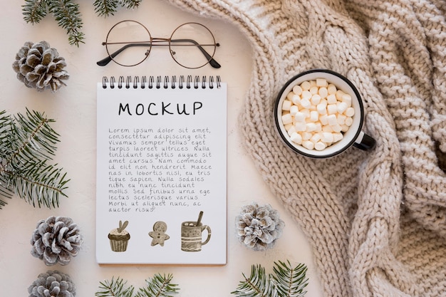 Top view of notebook with marshmallows and pine cones