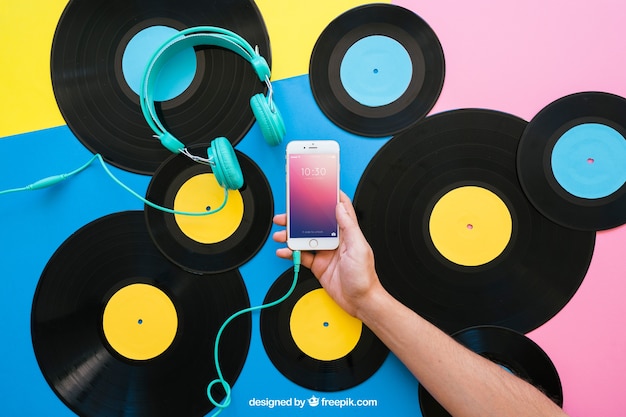 Free PSD vinyl mockup with hand holding smartphone