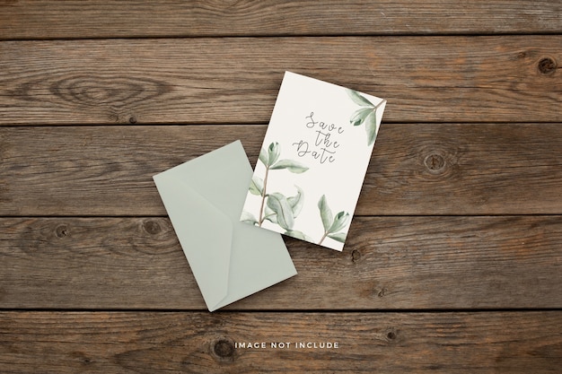 Free PSD wedding invitation template with beautiful leaves on a brown wooden background