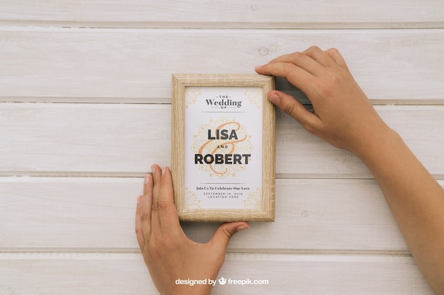 Free PSD wedding mock up with hands and wooden frame