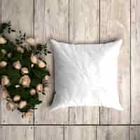 Free PSD white pillowcase mockup on a wooden floor with decorative roses