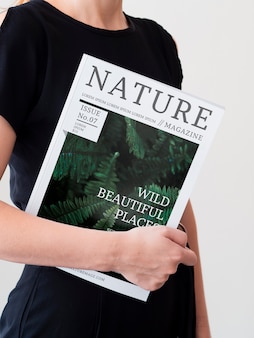 Woman in a black dress holding a magazine mock up