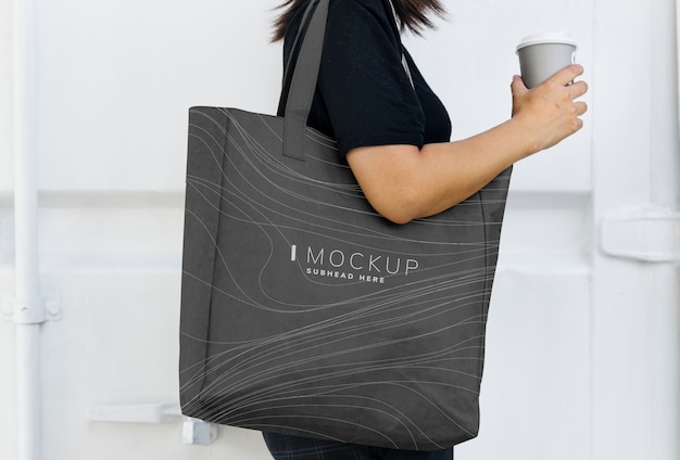 Woman carrying a black shopping bag mockup