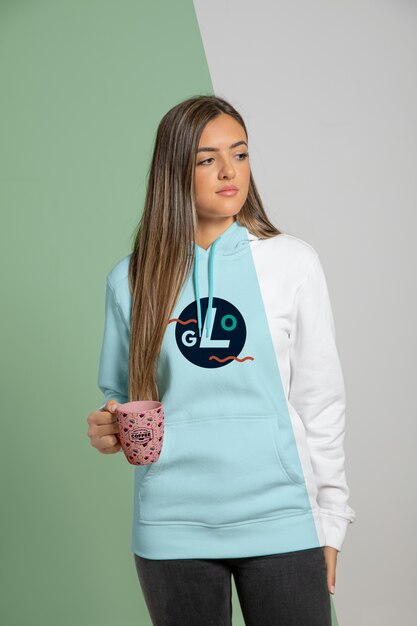 Woman dressed in hoodie holding mug