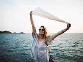 Free PSD woman in front of sea holding flag