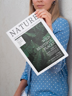 自然雑誌のモックアップを示す女性