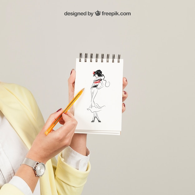 Woman showing drawing on notepad