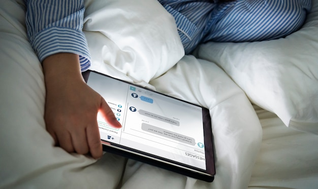 Free PSD a woman using a tablet in bed