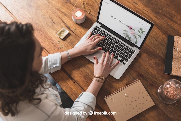 Woman working with laptop on wooden table – Free PSD Download