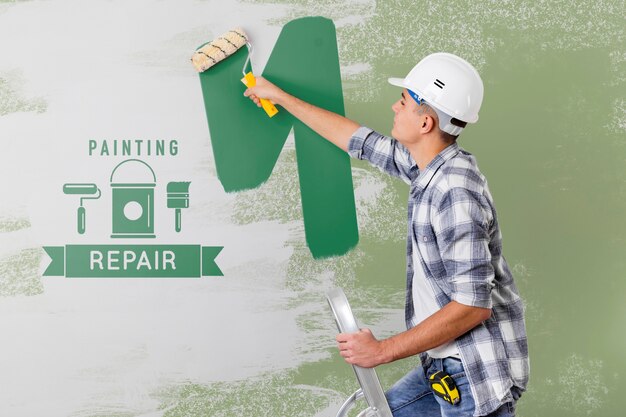 Young Handyman Painting The Wall In Green