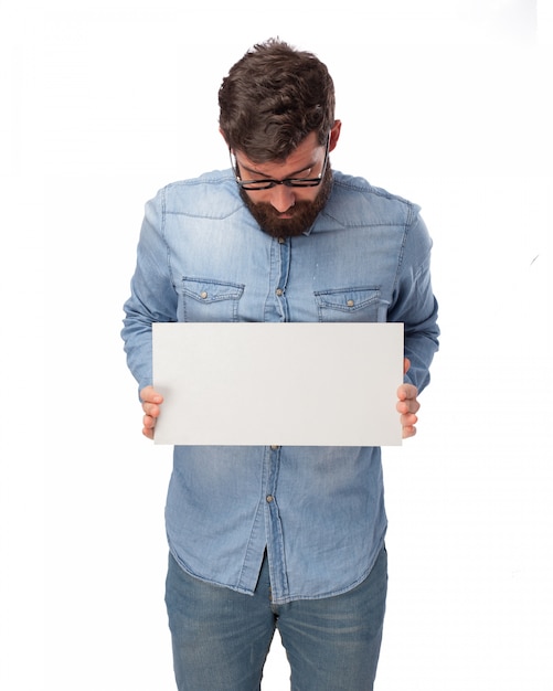 Young man holding a blank poster