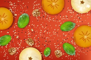 Кусочки фруктов яблока и хаки, грецкий орех, листья шпината, мак и кунжут на красном фоне. состав здоровой пищи