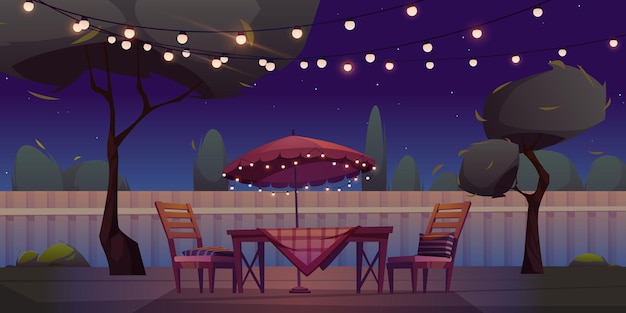 테이블과 화환이 있는 밤 뒤뜰의 바베큐 공간