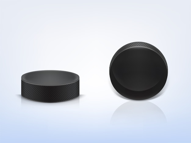 Black rubber puck to play ice hockey isolated on light background. Sport equipment.