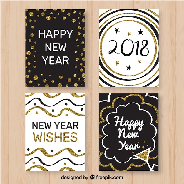 Free vector black and white new year cards with golden elements