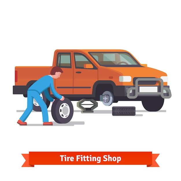 Car mechanic rolling tire to change it