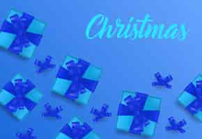 Free vector christmas lettering on blue background with gift boxes