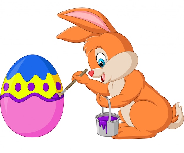 Premium Vector | Cartoon rabbit painting an easter egg