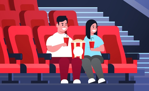 팝콘과 콜라 중량이 초과 된 남자 여자 날짜가 있고 새로운 코미디 평면 전체 길이 가로 웃고 영화관에 앉아 뚱뚱한 부부