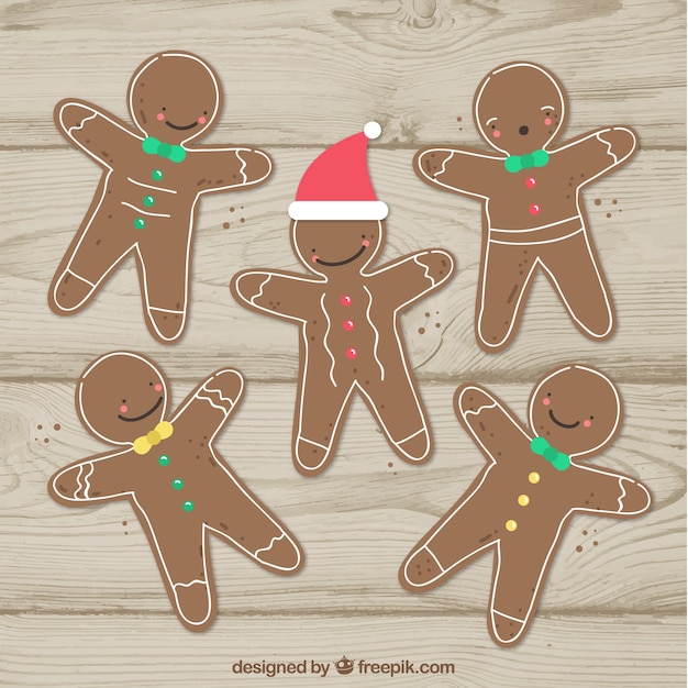 Free vector gingerbread man cookies on a wooden background