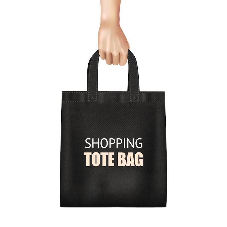 Free Vector hand holding fashionable black canvas shopping tote bag