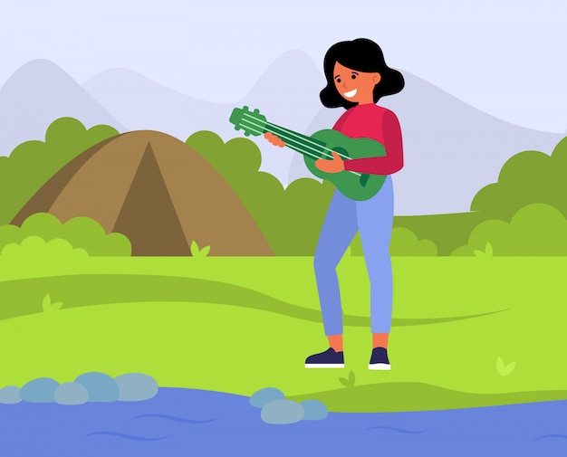 Happy woman playing guitar in countryside