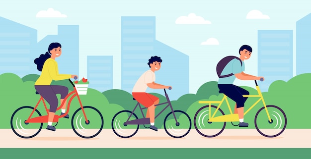 happy young family riding bicycles in city park
