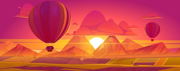 Hot air balloons flying above fields, mountains in red and orange colored sky on sunset or sunrise scenery landscape