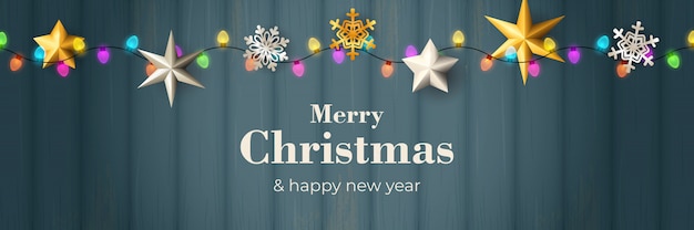 Merry Christmas banner with garland on blue wooden ground