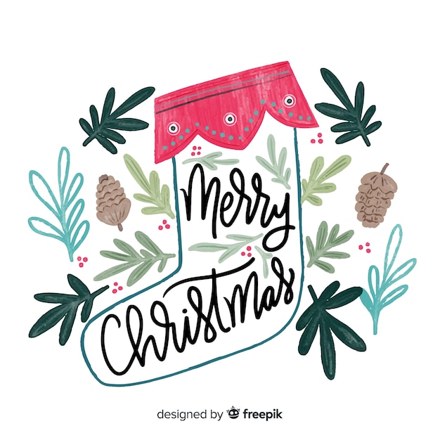 Vettore gratuito buon natale lettering con elementi naturali disegnati a mano