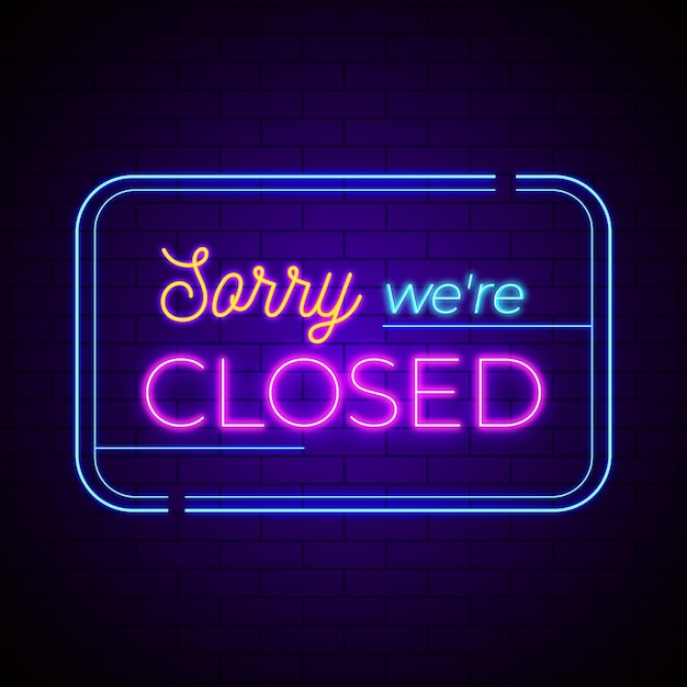 Neon 'sorry we are closed' sign on brick wall