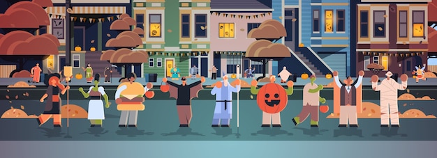 Люди в костюмах разных монстров гуляют по городу трюки и угощают счастливой вечеринкой в честь хэллоуина концепция празднования улица города здания внешний вид городской пейзаж
