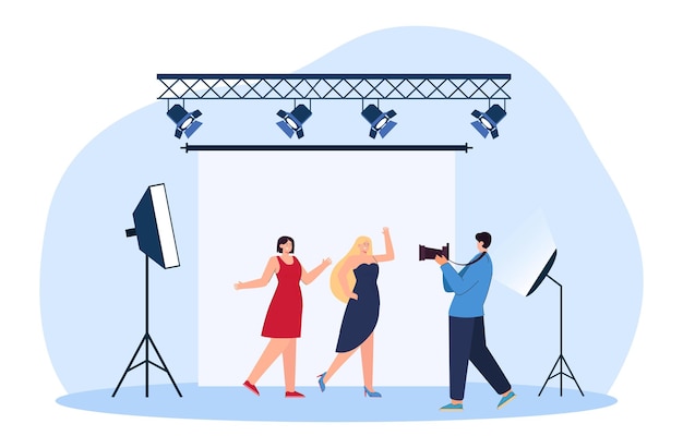 Photographer taking photos of models flat vector illustration. women in dresses posing for camera on backdrop in professional studio with light. photography, shooting concept