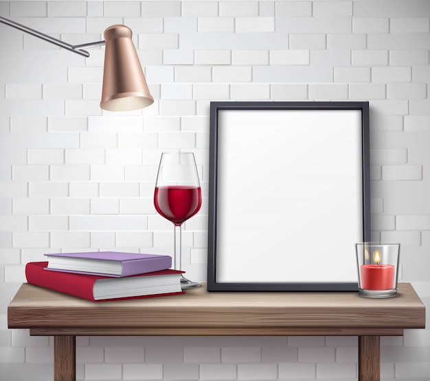 Realistic frame template on the table with glass of wine candle lamp and books 