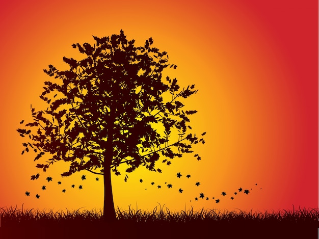 Silhouette of an autumn tree with leaves falling