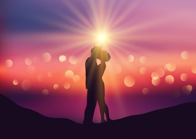 silhouette of kissing couple on a defocussed sunset background