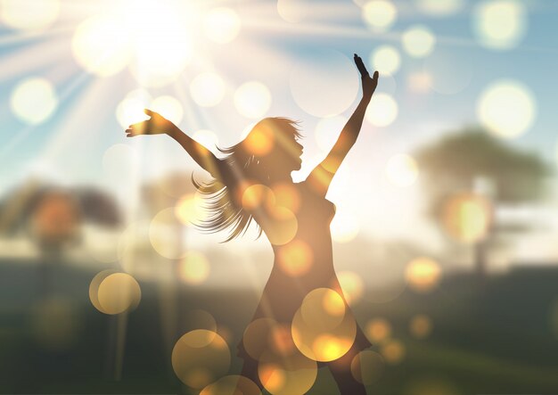 silhouette of young woman against sunlit defocussed landscape