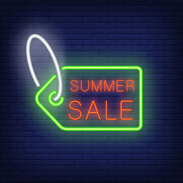 Summer sale text on tag in neon style. Green sale tag with red text on dark brick wall.