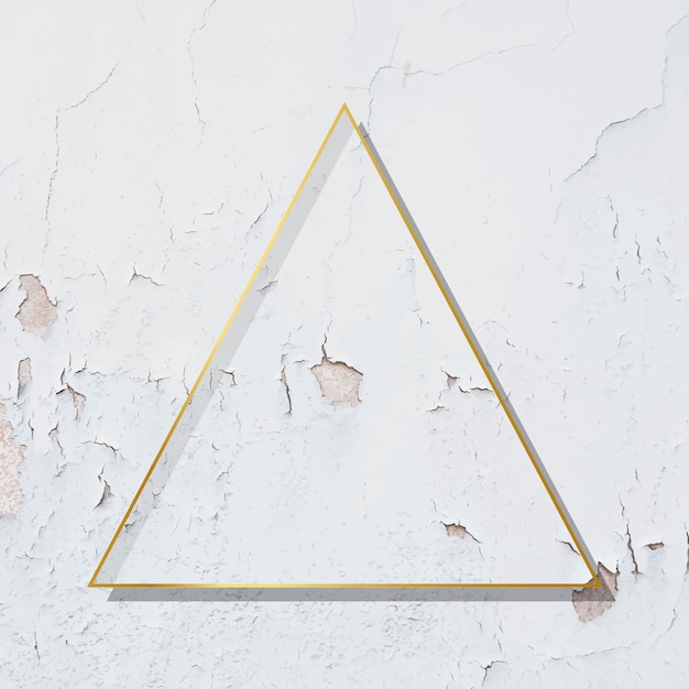 Triangle  gold frame on weathered white paint textured background