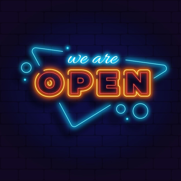 'we are open' neon sign on brick wall