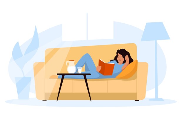 A woman holding a book relaxing at home on the sofa