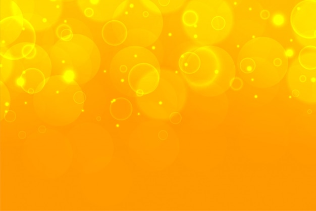 Free vector yellow shimmering bokeh sparkles beautiful background design