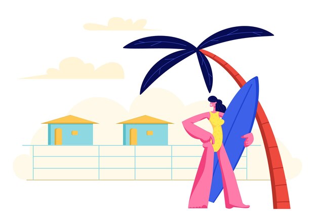 Молодая девушка с доской для серфинга в руках, стоя на песчаном пляже под пальмой на фоне курортных домиков