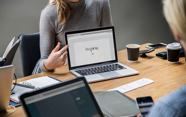 Blondine, die auf einen Laptopschirm zeigen