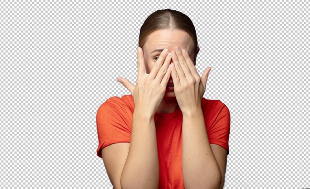 das Gesicht mit den Händen bedeckt, zwischen den Fingern mit überraschtem Ausdruck guckt und zur Seite schaut