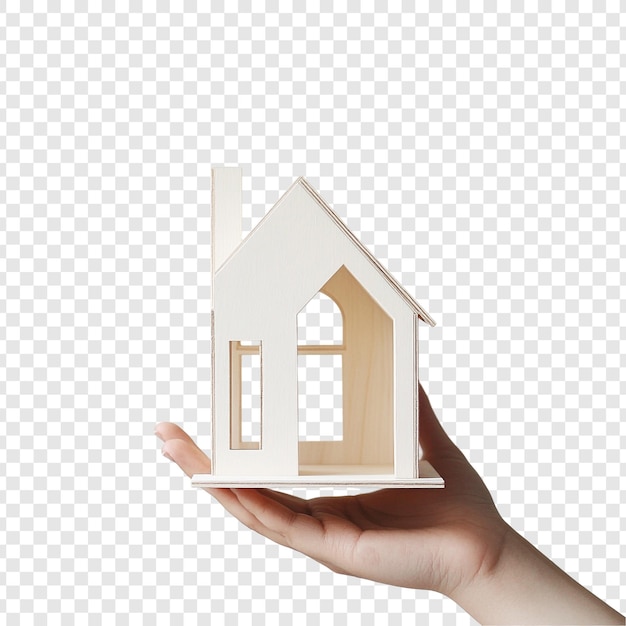 Eine Hand hält ein Modell eines Miniaturhauses aus Holz, das den Traum darstellt, ein Haus zu besitzen